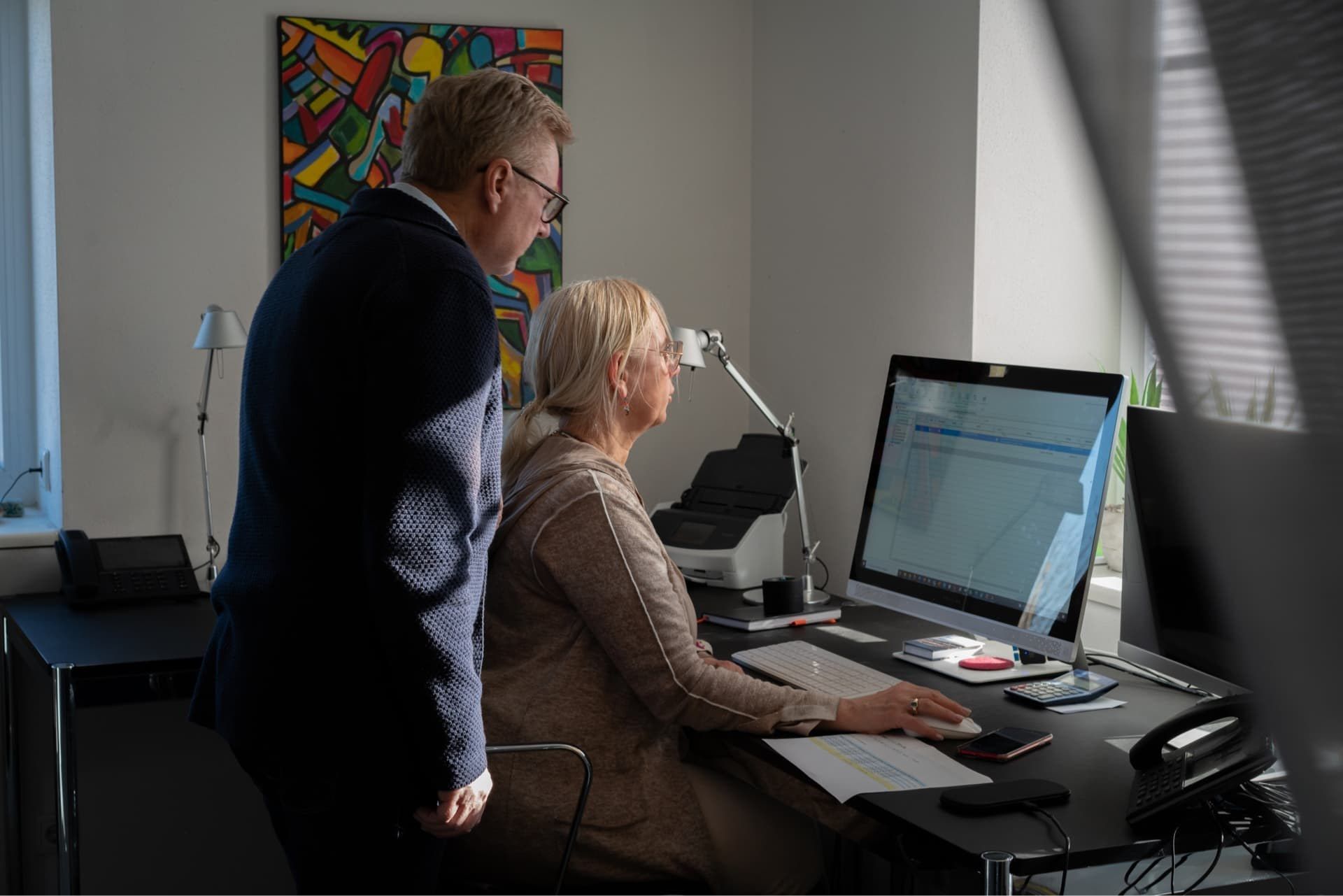 Klaus und Dea Heisig arbeiten gemeinsam am Bildschirm im Büro